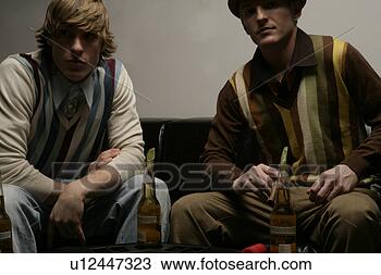 Banco de Imagem - dois,  jovem, 
 men,  sentando, 
 baixo,  olhar, 
 câmera. fotosearch 
- busca de fotos, 
imagens e clipart