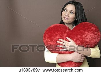 Picture - portrait of a 
teenage girl holding 
a stuffed heart. 
fotosearch - search 
stock photos, 
pictures, images, 
and photo clipart