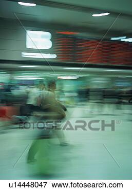 Picture - traveler walking 
with luggage at 
airport, blurred 
motion. fotosearch 
- search stock 
photos, pictures, 
images, and photo 
clipart