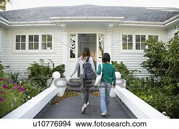 Stock Photo - two young women 
walking towards 
house. fotosearch 
- search stock 
photos, pictures, 
images, and photo 
clipart