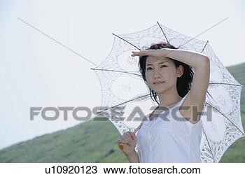 Banco de Imagem - jovem,  mulher, 
 ficar,  parasol. 
fotosearch - busca 
de fotos, imagens 
e clipart