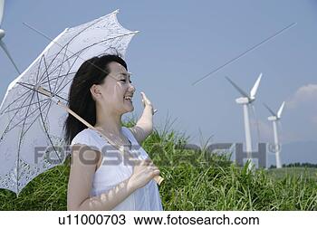Banco de Imagem - jovem,  mulher, 
 ficar,  parasol. 
fotosearch - busca 
de fotos, imagens 
e clipart