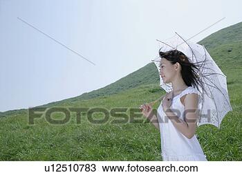 Banco de Imagem - jovem,  mulher, 
 ficar,  parasol. 
fotosearch - busca 
de fotos, imagens 
e clipart