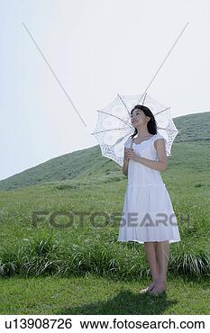 Banco de Imagem - jovem,  mulher, 
 ficar,  parasol. 
fotosearch - busca 
de fotos, imagens 
e clipart