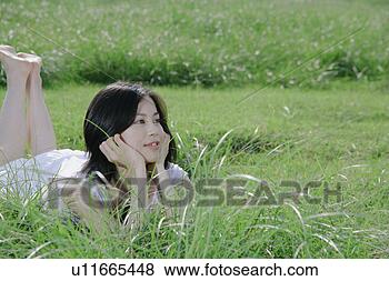 Banco de Imagem - jovem,  mulher, 
 mentindo,  capim, 
 campo. fotosearch 
- busca de fotos, 
imagens e clipart