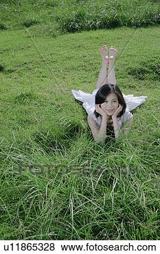 Banco de Imagem - jovem,  mulher, 
 mentindo,  capim, 
 campo. fotosearch 
- busca de fotos, 
imagens e clipart