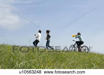 Banco de Imagem - jovem,  mulher, 
 montando,  bicicleta, 
 atrás de,  dois, 
 jovem,  men. 
fotosearch - busca 
de fotos, imagens 
e clipart