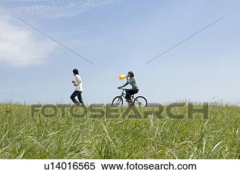 Banco de Imagem - jovem,   mulher, 
  montando,   
bicicleta,   atrás 
de,   jovem,  
 men. fotosearch 
- busca de fotos, 
imagens e clipart