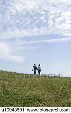Arquivo de Fotografia - jovem,  par,  
andar,  segurando, 
 mãos,  parte 
traseira,  vista. 
fotosearch - busca 
de fotos, imagens 
e clipart