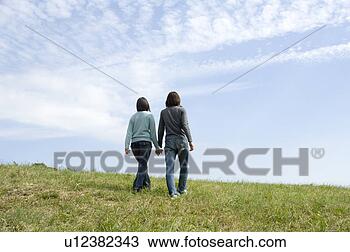 Banco de Imagem - jovem,  par,  
andar,  segurando, 
 mãos,  parte 
traseira,  vista. 
fotosearch - busca 
de fotos, imagens 
e clipart