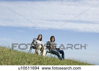 Banco de Imagem - jovem,  par,  
sentando,  cadeiras. 
fotosearch - busca 
de fotos, imagens 
e clipart