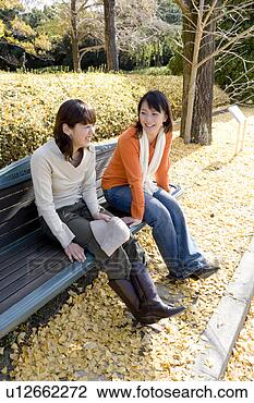 Banco de Imagem - dois,  jovem, 
 mulheres,  sentando, 
 banco. fotosearch 
- busca de fotos, 
imagens e clipart