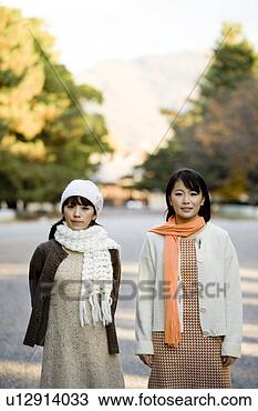 Banco de Imagem - dois,  jovem, 
 mulheres,  ficar, 
 olhar,  câmera. 
fotosearch - busca 
de fotos, imagens 
e clipart