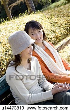 Arquivo Fotográficos - dois,  jovem, 
 mulheres,  sentando, 
 banco. fotosearch 
- busca de fotos, 
imagens e clipart