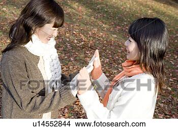 Banco de Imagem - dois,  jovem, 
 mulheres,  tocar, 
 mãos. fotosearch 
- busca de fotos, 
imagens e clipart