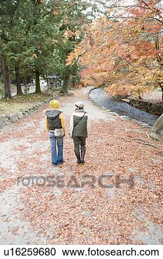 Stock Photography - two young women 
walking, kamigamo 
shrine, kyoto 
prefecture, japan. 
fotosearch - search 
stock photos, 
pictures, images, 
and photo clipart