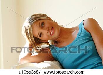 Foto - mulher,  relaxante, 
 sofá. fotosearch 
- busca de fotos, 
imagens e clipart