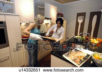Arquivo de Fotografia - dois,  jovem, 
 mulheres,  assando, 
 lar. fotosearch 
- busca de fotos, 
imagens e clipart
