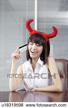 Stock Photo - young woman wearing 
two red horn, 
holding a credit 
card. fotosearch 
- search stock 
photos, pictures, 
images, and photo 
clipart