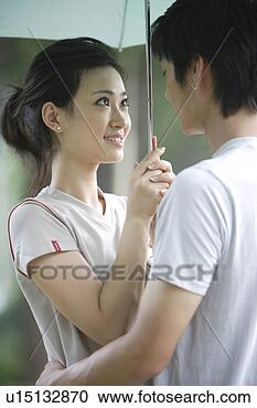 Stock Photography - young couple holding 
an umbrella, embracing. 
fotosearch - search 
stock photos, 
pictures, images, 
and photo clipart