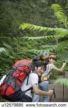 Stock Image - young couple carrying 
gripesacks,  climbing 
on stone steps 
with a. fotosearch 
- search stock 
photos, pictures, 
images, and photo 
clipart