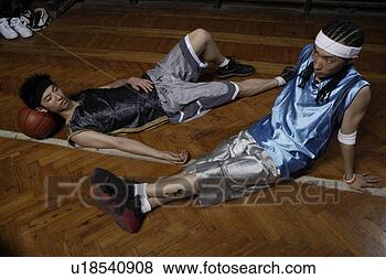 Stock Photo - tow young basketball 
players resting 
on floor. fotosearch 
- search stock 
photos, pictures, 
images, and photo 
clipart