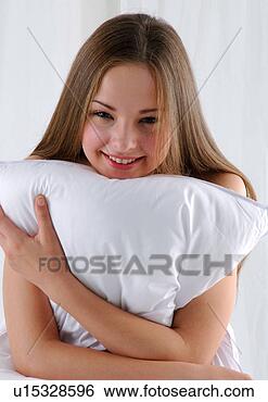 Stock Photo - close-up of a 
young woman hugging 
a pillow and smiling. 
fotosearch - search 
stock photos, 
pictures, images, 
and photo clipart