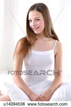 Stock Photo - portrait of a 
young woman kneeling 
on the bed with 
a pillow and. 
fotosearch - search 
stock photos, 
pictures, images, 
and photo clipart