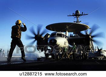 Stock Image - an aircraft flight 
deck director 
guides an e-2c 
hawkeye onto a 
steam. fotosearch 
- search stock 
photos, pictures, 
images, and photo 
clipart