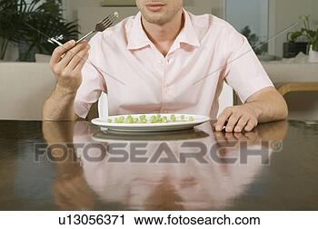 Stock Photography - young man eating 
peas. fotosearch 
- search stock 
photos, pictures, 
images, and photo 
clipart