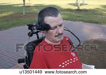 Stock Photograph - man with a disability 
utilizing a mouthpiece 
to maneuver his. 
fotosearch - search 
stock photos, 
pictures, images, 
and photo clipart