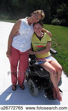 Stock Image - mom gives daughter 
(electric wheelchair 
user) a hug for 
the camera. fotosearch 
- search stock 
photos, pictures, 
images, and photo 
clipart