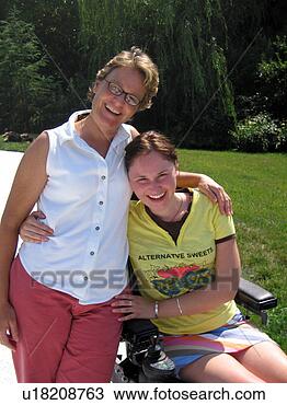 Stock Photo - mother and daughter 
(seated in electric 
wheelchair) share 
a hug for. fotosearch 
- search stock 
photos, pictures, 
images, and photo 
clipart