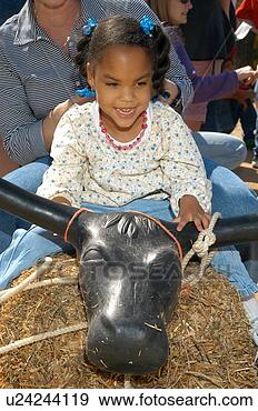 Stock Photograph - little girl with 
multiple disabilities 
riding a pretend 
bull at a fun. 
fotosearch - search 
stock photos, 
pictures, images, 
and photo clipart