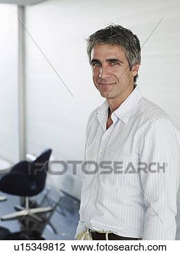 Stock Photo - businessman wearing 
open neck shirt 
in office, smiling, 
portrait. fotosearch 
- search stock 
photos, pictures, 
images, and photo 
clipart