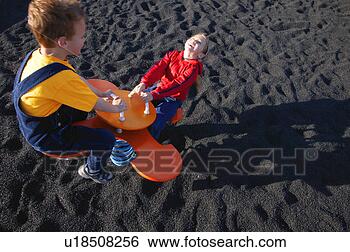 Stock Photo - children on see-saw 
at the park. fotosearch 
- search stock 
photos, pictures, 
images, and photo 
clipart