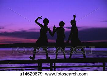 Stock Photograph - three silhouettes 
of boys on a dock 
against a sunset. 
fotosearch - search 
stock photos, 
pictures, images, 
and photo clipart