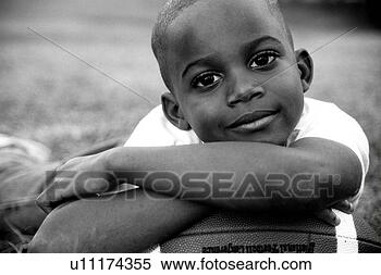 Stock Image - african american 
boy resting his 
head on a football 
and smiling at 
you. fotosearch 
- search stock 
photos, pictures, 
images, and photo 
clipart
