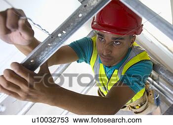 Stock Photo - builder fitting 
studs for drywall 
partition and 
ceiling fixing. 
fotosearch - search 
stock photos, 
pictures, images, 
and photo clipart