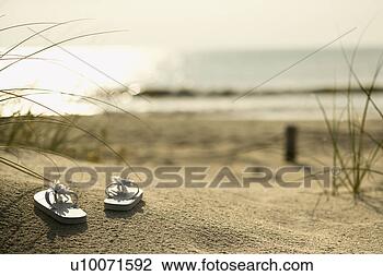 Stock Photo - two white sandals 
on sandy beach 
with ocean in 
background. fotosearch 
- search stock 
photos, pictures, 
images, and photo 
clipart