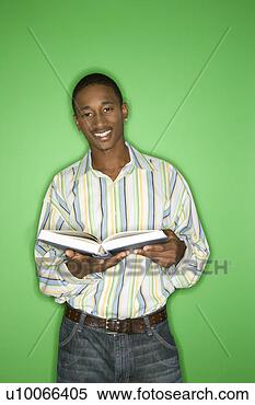 Stock Image - portrait of smiling 
african-american 
teen boy holding 
a book standing. 
fotosearch - search 
stock photos, 
pictures, images, 
and photo clipart