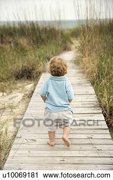 Stock Photography - caucasian male 
toddler walking 
on beach access 
walkway toward 
beach. fotosearch 
- search stock 
photos, pictures, 
images, and photo 
clipart