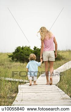 Stock Photography - caucasian pre-teen 
girl walking on 
beach access walkway 
and holding. fotosearch 
- search stock 
photos, pictures, 
images, and photo 
clipart