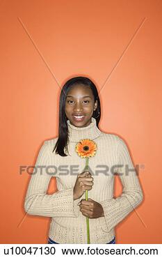 Stock Photography - portrait of african-american 
teen girl holding 
single gerbera 
daisy. fotosearch 
- search stock 
photos, pictures, 
images, and photo 
clipart