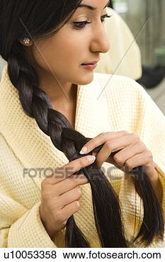 Stock Photo - close up profile 
of asian/indian 
young woman braiding 
hair. fotosearch 
- search stock 
photos, pictures, 
images, and photo 
clipart