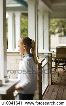 Stock Photography - side view of caucasian 
pre-teen girl 
standing on porch. 
fotosearch - search 
stock photos, 
pictures, images, 
and photo clipart
