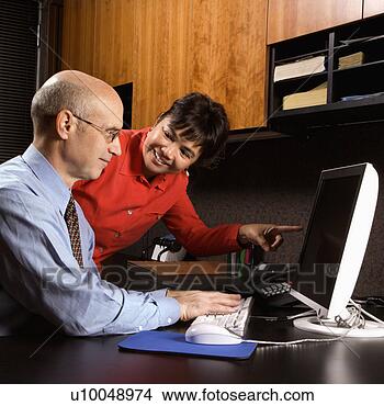 Stock Photo - businessman and 
businesswoman 
in office smiling 
looking and pointing. 
fotosearch - search 
stock photos, 
pictures, images, 
and photo clipart