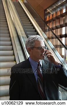 Stock Photograph - rear view of adult 
caucasian man 
in suit standing 
on escalator. 
fotosearch - search 
stock photos, 
pictures, images, 
and photo clipart