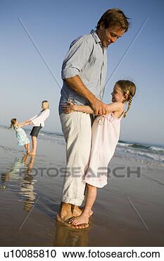 Stock Photography - family playing 
on beach. fotosearch 
- search stock 
photos, pictures, 
images, and photo 
clipart