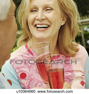 Stock Photography - mature couple 
holding champagne 
flutes and smiling. 
fotosearch - search 
stock photos, 
pictures, images, 
and photo clipart
